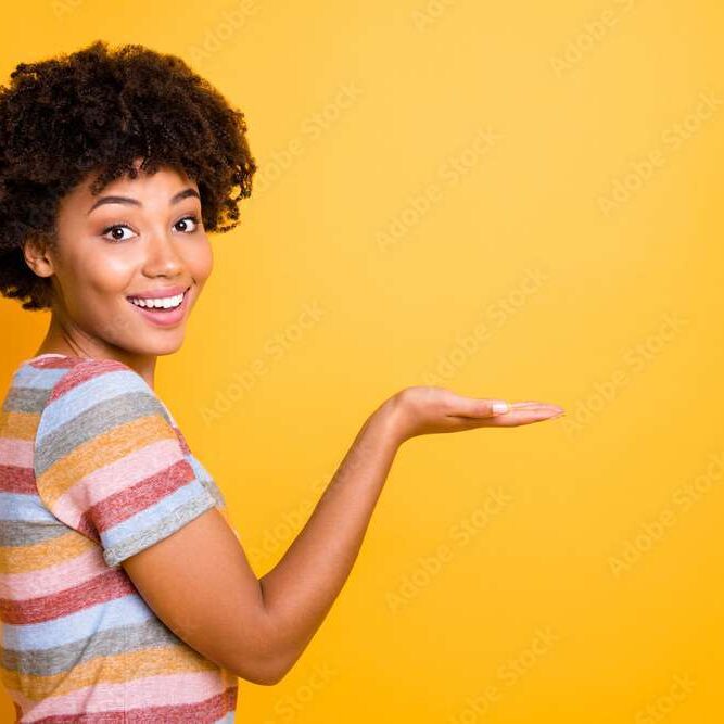 Profile photo of amazing dark skin lady holding new offer price product on open palm wear casual striped t-shirt isolated on yellow background