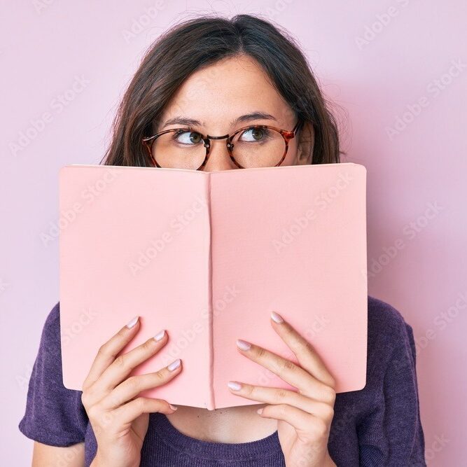 Young beautiful woman wearing glasses reading book smiling looking to the side and staring away thinking.